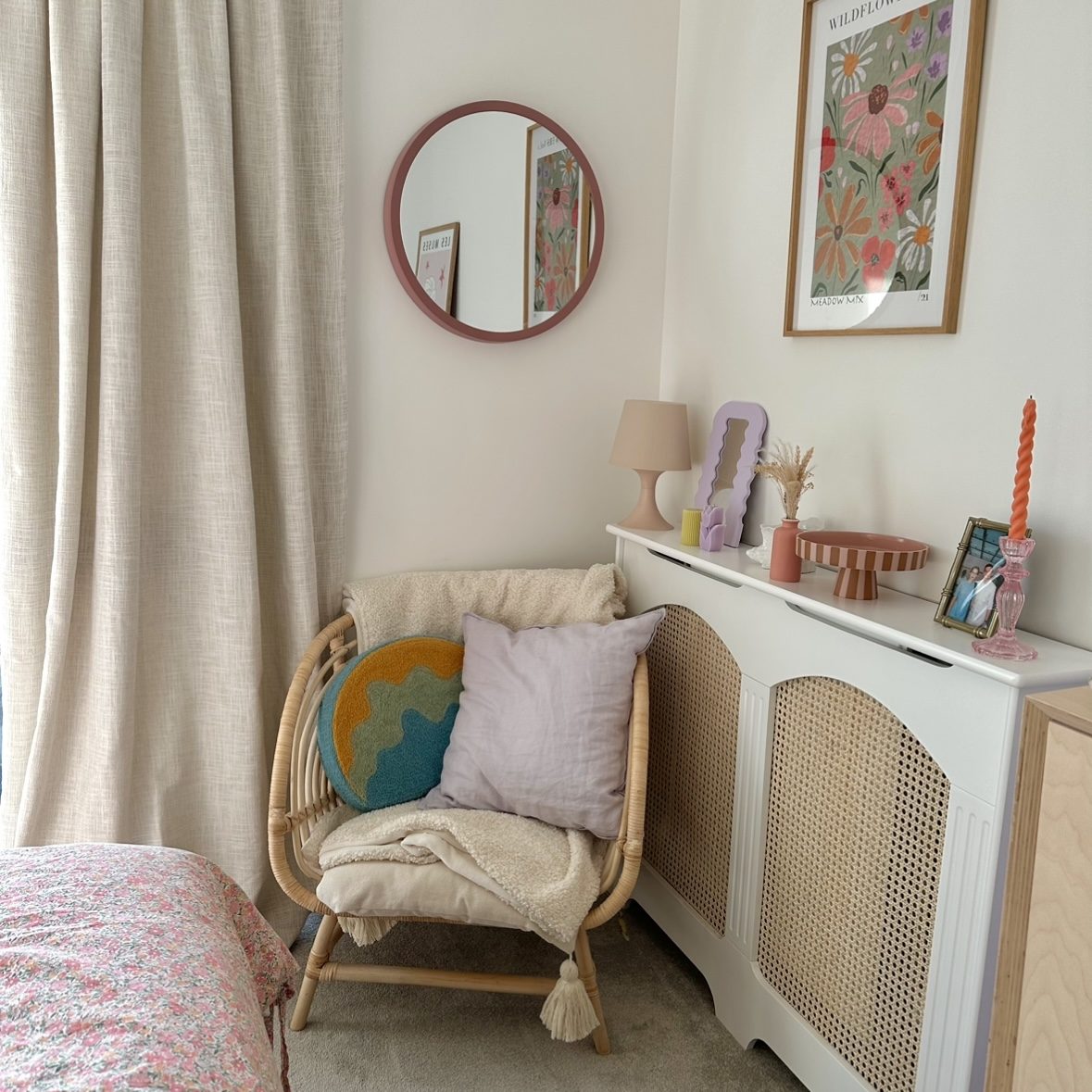 Corner of bedroom with long curtains.