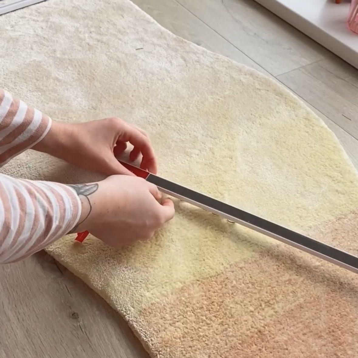 Image of person peeling off sticker to reveal adhesive strip on the back of the curtain track.