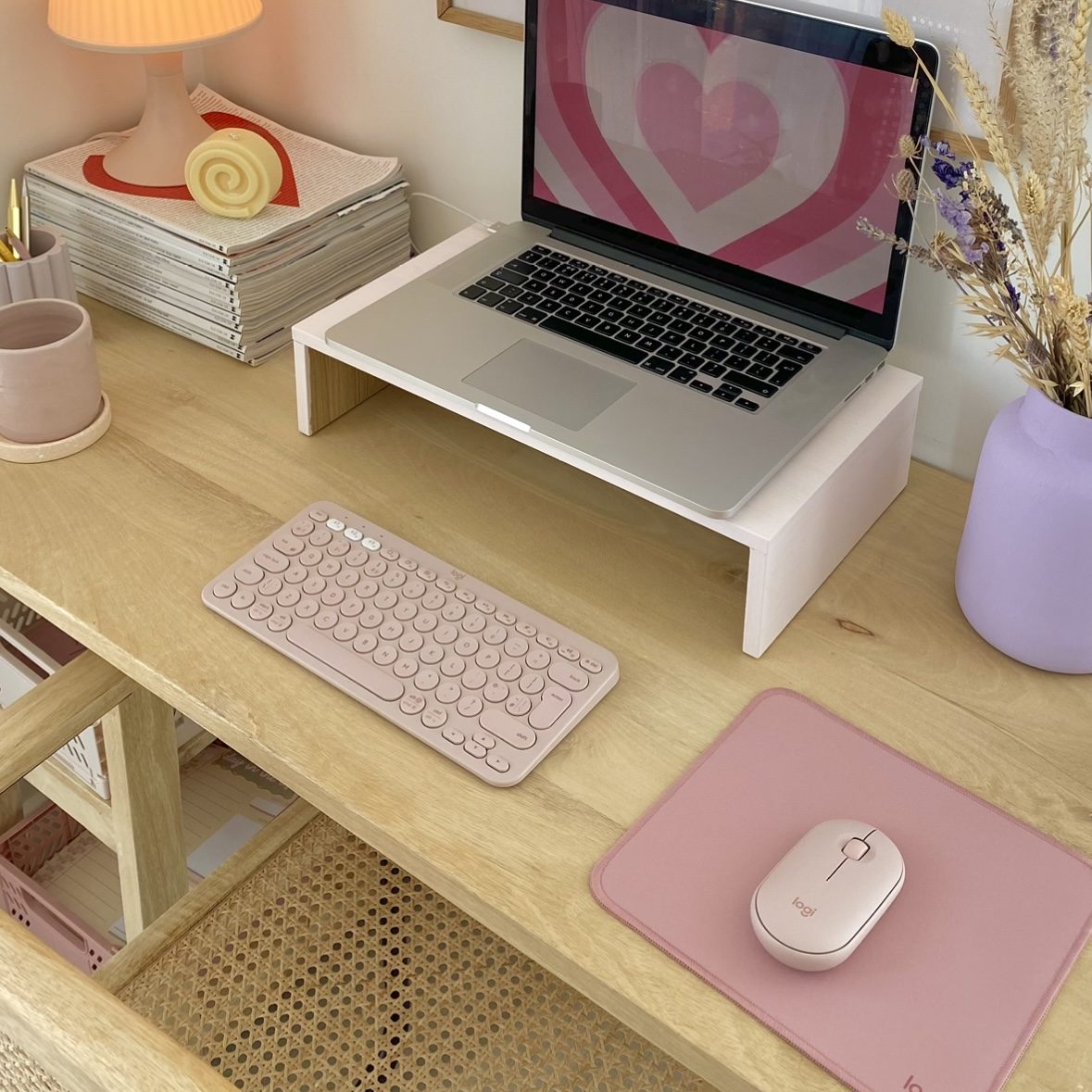 Desk set up that features a pink mouse and keyboard.